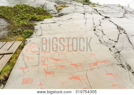 Rock Art In Alta Fjord, Norway. Ancient Symbols, Real Drawing,  Texture In Stone. Red Ocher Paint. H