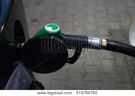 Close Up Fueling Gun In A Dark Car Gas Tank