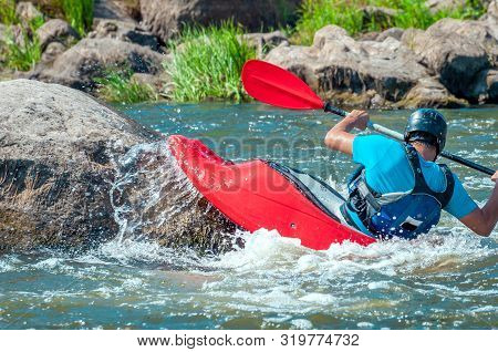 Playboating. A Man Sitting In A Kayak With Oars In His Hands Performs Exercises On The Water. Kayaki