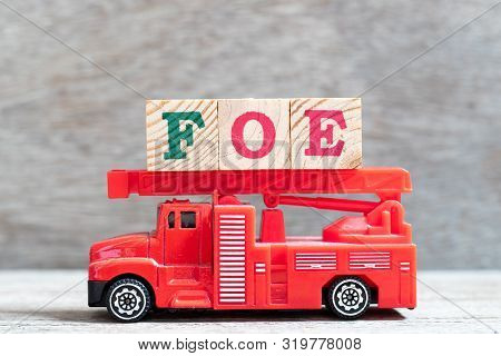 Red Fire Truck Hold Letter Block In Word Foe On Wood Background