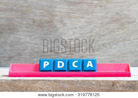 Tile Letter On Red Rack In Word Pdca (business Abbreviation Of Plan Do Check Act) On Wood Background