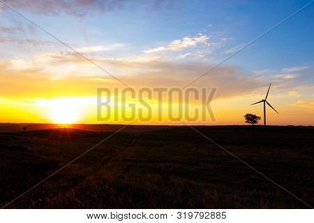 Silhouette Of A Wind Farm Against The Backdrop Of The Setting Sun