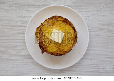 Top View, Homemade Corn Meal Johnny Cakes With Butter On A White Plate On A White Wooden Background.