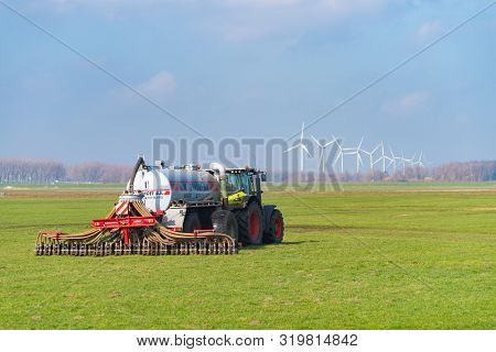 Nijkerk, Netherlands - March 2, 2019: Tractor With Liquid Manure Injector Fertilizing A Meadow