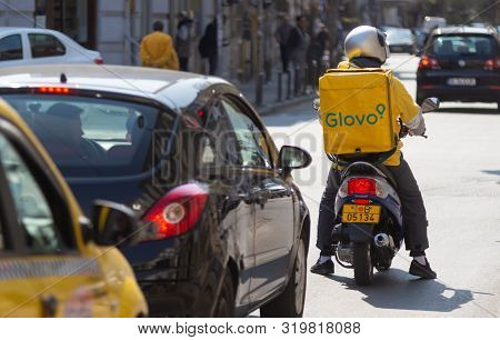 Bucharest, Romania - April 03, 2019: A Glovo Food Delivery Courier Delivers Food In Bucharest, Roman