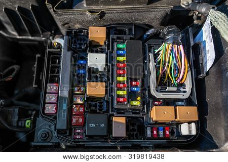 Plastic Fuse Box Inside The Engine Compartment, Visible Fuses, Relays And Electrical Cable Harness.