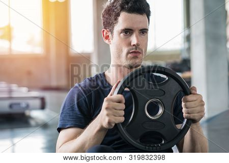 Handsome Weightlifter Lifting Plates Dumbbell In Gym Exercise With Work Out Program For Healthy