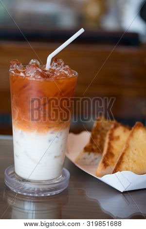 Thai Iced Milk Tea In The Breakfast Served With Garlic Bread