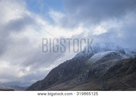 Stunning Moody Dramatic Winter Landscape Image Of Snowcapped Tryfan Mountain In Snowdonia During Sto