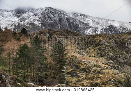 Stunning Dramatic Landscape Images Of Ogwen Valley In Snowdonia During Winter With Snowcapped Glyers