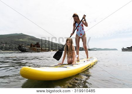 Mom And Daughter Ride A Glanders Board.