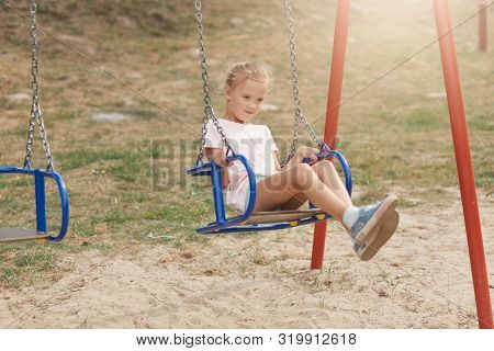 Outdoor Shot Of Charming Kid Playing In Park, Little Girl In Kinderatren Anf Looks Happy, Expressing