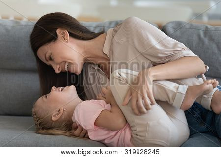 Close Up Image Cheerful Mother Embraces Tickles Little Daughter