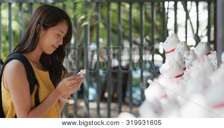 Woman put a little cat into Gotokuji temple 
