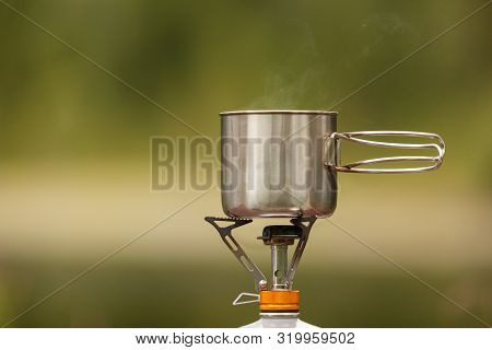 The Camping Iron Mug With A Gas Burner On Background