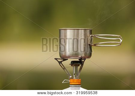 The Camping Iron Mug With A Gas Burner On Background