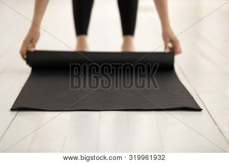 Woman Practicing Yoga, Rolling Black Mat On Floor Close Up