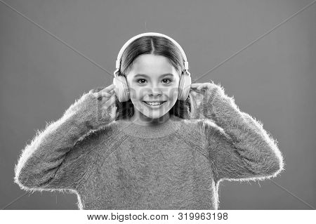 Using Bluetooth Wireless Technology. Little Child Listening To Music In Bluetooth Stereo Earphones. 