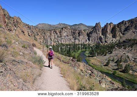 Young Woman On Misery Ridge Trail In Smith Rock State Park Near Terrebonne, Oregon On A Coudless Sum