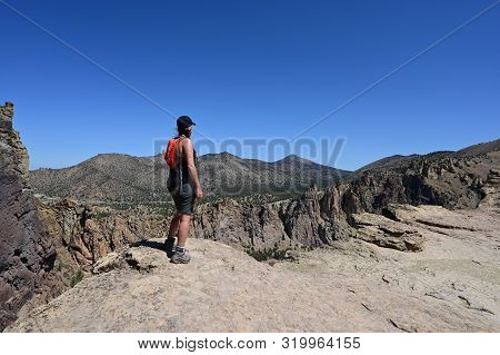 Young Woman On Misery Ridge Trail In Smith Rock State Park Near Terrebonne, Oregon On A Coudless Sum