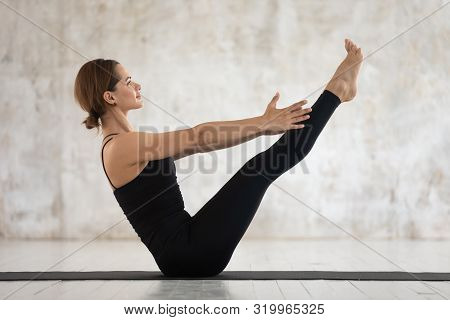Sporty Woman Practicing Yoga, Doing Paripurna Navasana Exercise