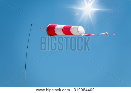 Windsock On A Background Of Blue Sky On A Sunny Day. High Wind Speed, Strong Wind.