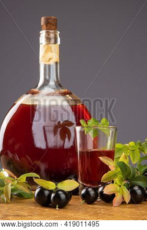 Jaboticaba, Bottle And Glass Of Homemade Brazilian Jaboticaba Liqueur On Wood With Leaves And Branch