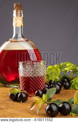 Jaboticaba, Bottle And Glass Of Homemade Brazilian Jaboticaba Liqueur On Wood With Leaves And Branch