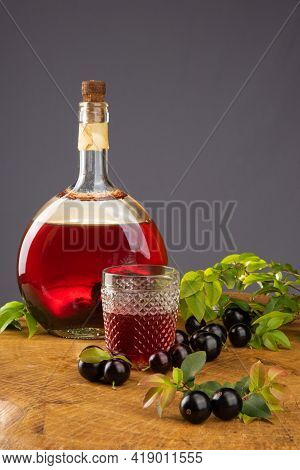Jaboticaba, Bottle And Glass Of Homemade Brazilian Jaboticaba Liqueur On Wood With Leaves And Branch