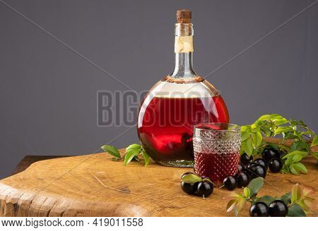Jaboticaba, Bottle And Glass Of Homemade Brazilian Jaboticaba Liqueur On Wood With Leaves And Branch