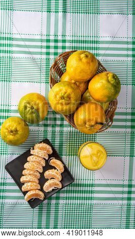 Orange Ponkan, Orange Ponkan Slices On A Black Plate, Plus Some Oranges And A Glass Of Juice On A Ch