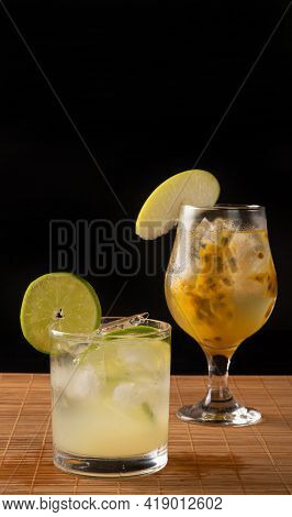 Brazilian Drink, Sake Caipirinha With Passion Fruit And Sake Caipirinha With Lemon On A Wooden Mat,