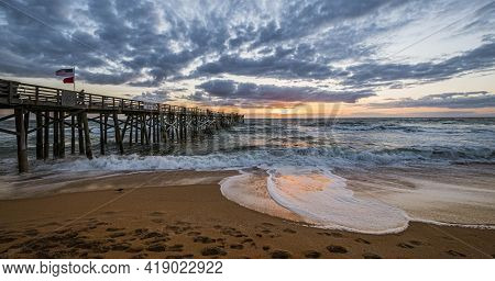 Seascape Of  Fishermen And An American Flag Blowing In The Wind On The Flagler Beach, Florida Fishin