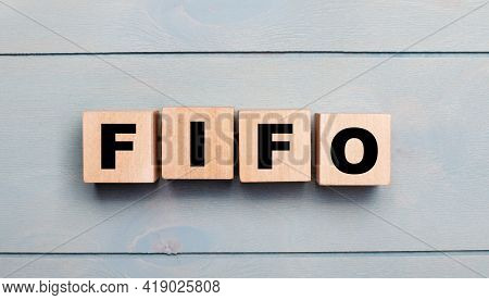 Wooden Cubes With The Text Fifo First In, First Out On A Light Blue Wooden Background.