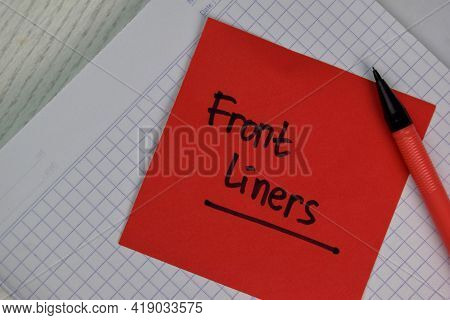 Front Liners Write On Sticky Notes Isolated On Wooden Table.