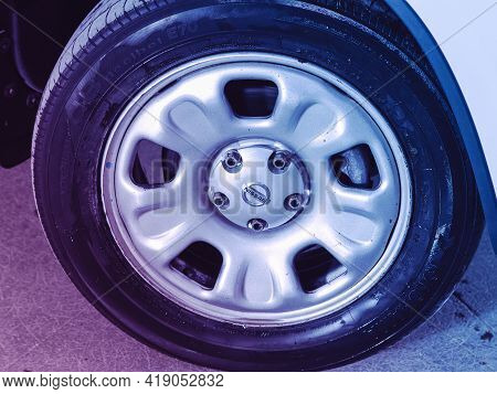 Novosibirsk, Russia - April 25 2021: Nissan Terrano, Car Wheel On White Car - Close Up Under Pink Ne