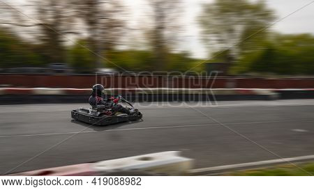 A Panning Shot Of A Racing Kart As It Circuits A Track.