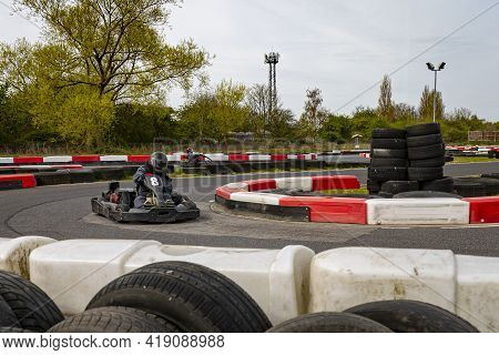 A Panning Shot Of A Racing Kart As It Circuits A Track.