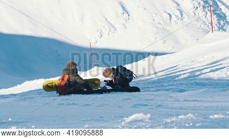 Kasprowy Wierch, Poland 28.01.2021 - Two Skiers Sitting On A Snow-covered Mountain - Skiers Taking A