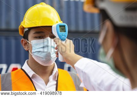Asian Man Worker Wearing Face Mask Checking Fever By Digital Thermometer Before Entering The Work Fo