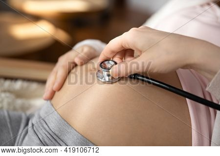Close Up Of Doctor Listen To Baby Bump