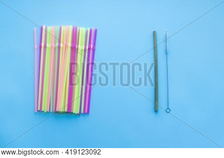Many Plastic Drinking Straws Vs One Reusable Bamboo Drinking Straw On A Blue Background. Zero Waste 