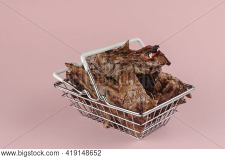 Shopping Basket With Dog Treats On A Pink Background. Natural Treats In A Metal Basket. Dried Beef L