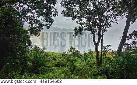 Streams Of Water Rush Down From The Edge Of The Gorge. Victoria Falls Are Shrouded In Thick Fog. In 