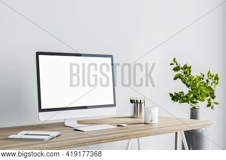 Blank White Computer Monitor As A Part Of Stylish Home Work Place With Modern Grey Vase On Floor At 