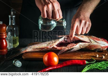 Chef Or Cook Prepares Fresh Fish Bighead Carp With Add Vinegar. Preparation For Cooking Herring. Wor