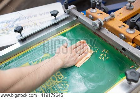 Serigraphy Silk Screen Print Process At Clothes Factory. Cleansing Frame, Squeegee And Plastisol Col