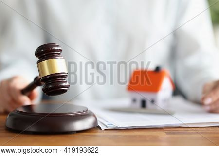 Judge Holding Wooden Hammer Near Toy Little House Closeup
