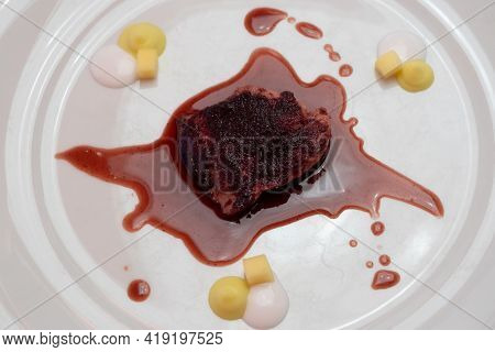 Quail Breast With Purple Curry, Red Wine Jus, Mango And Coconut Cream On A White Plate