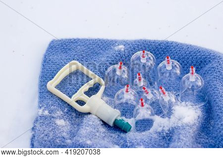 Jars for hijama in a basket in the snow. Wicker basket. Bloodletting according to the Sunnah. Vacuum